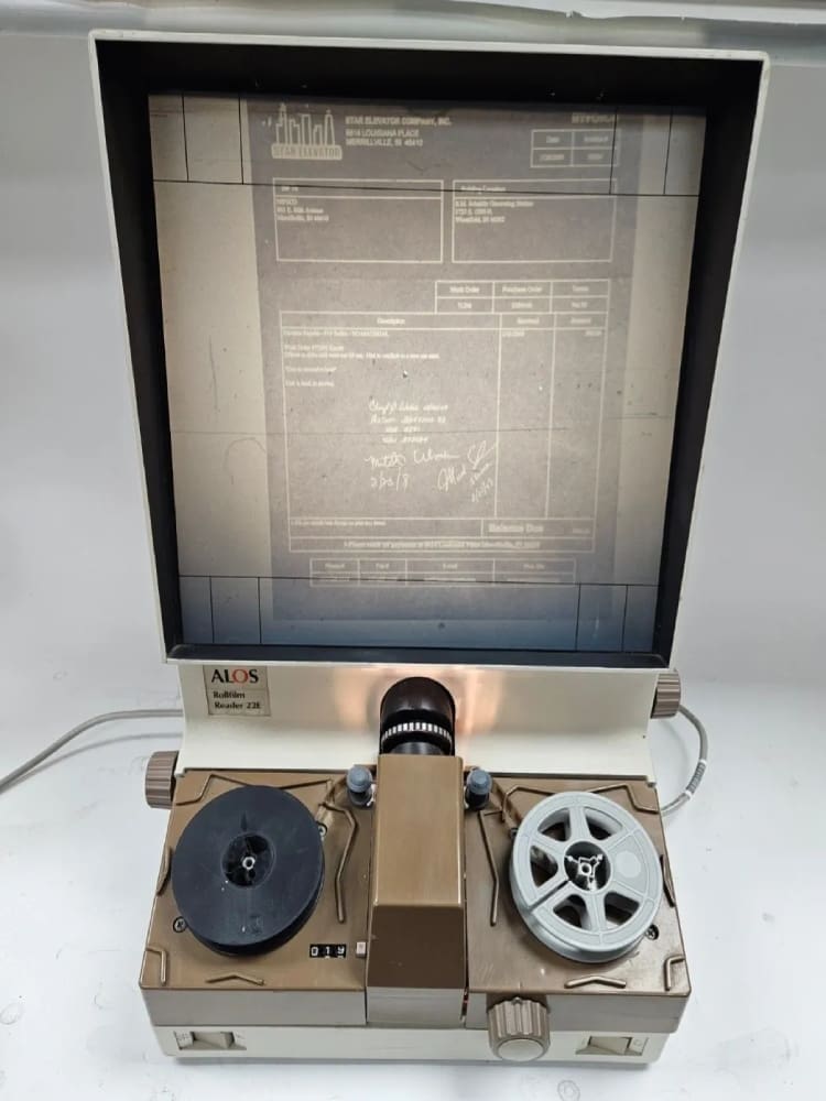 Vintage microfilm reader with document displayed.